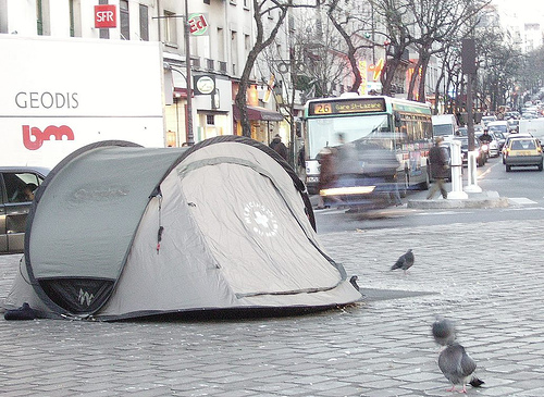 A tent on a busy street used by people without a home