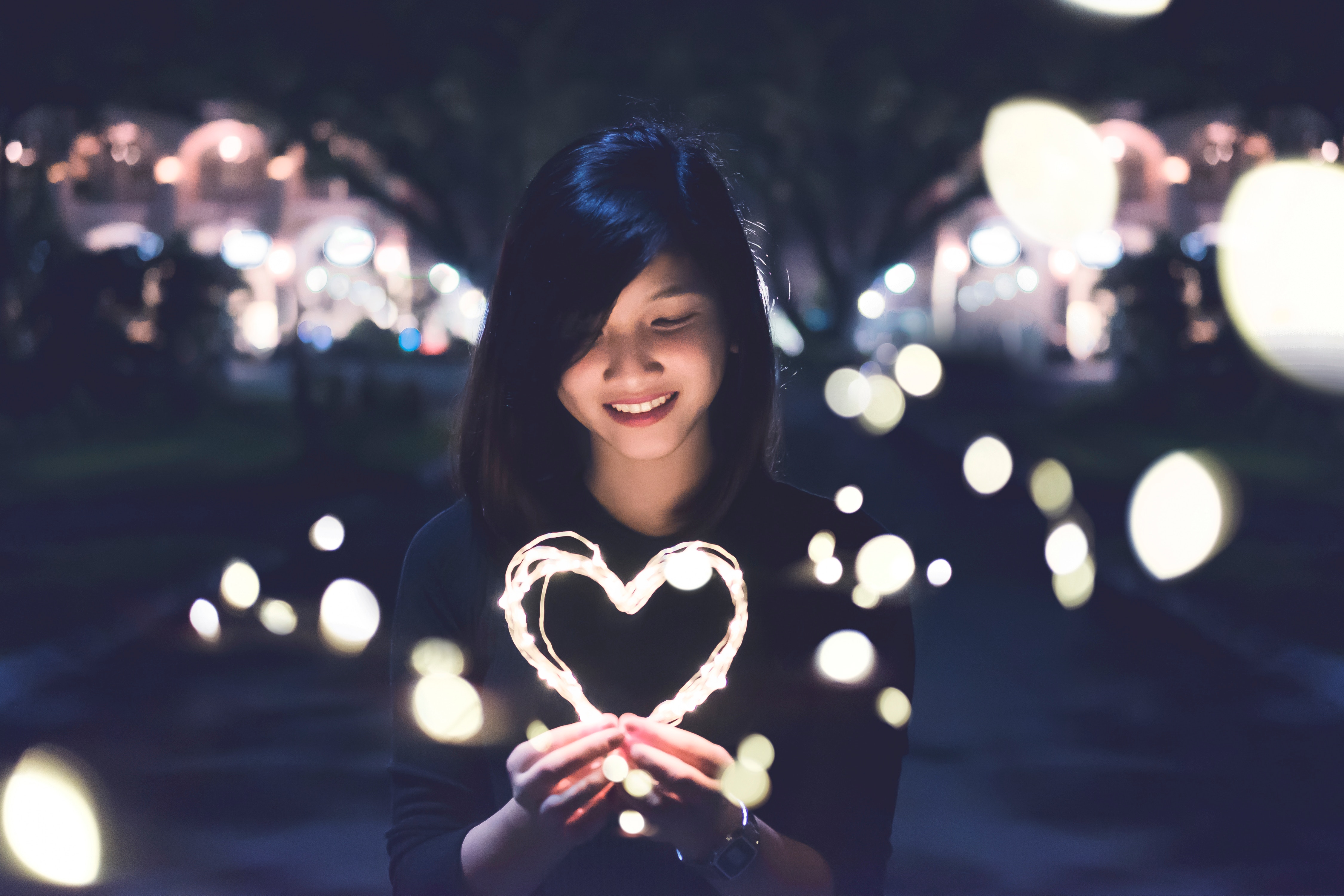 A girl holding a heart shape light