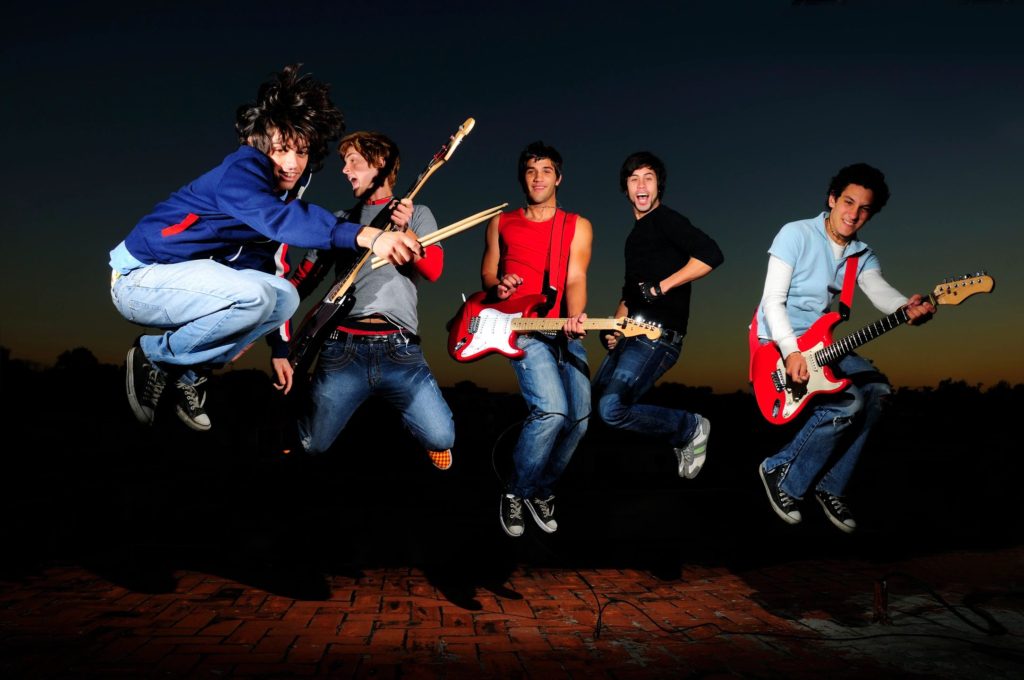 a music band and each member is holding a guitar
