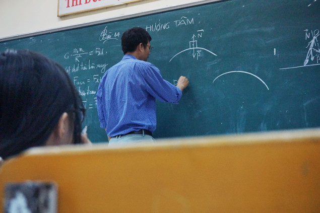 the professor is illustrating something on the blackboard